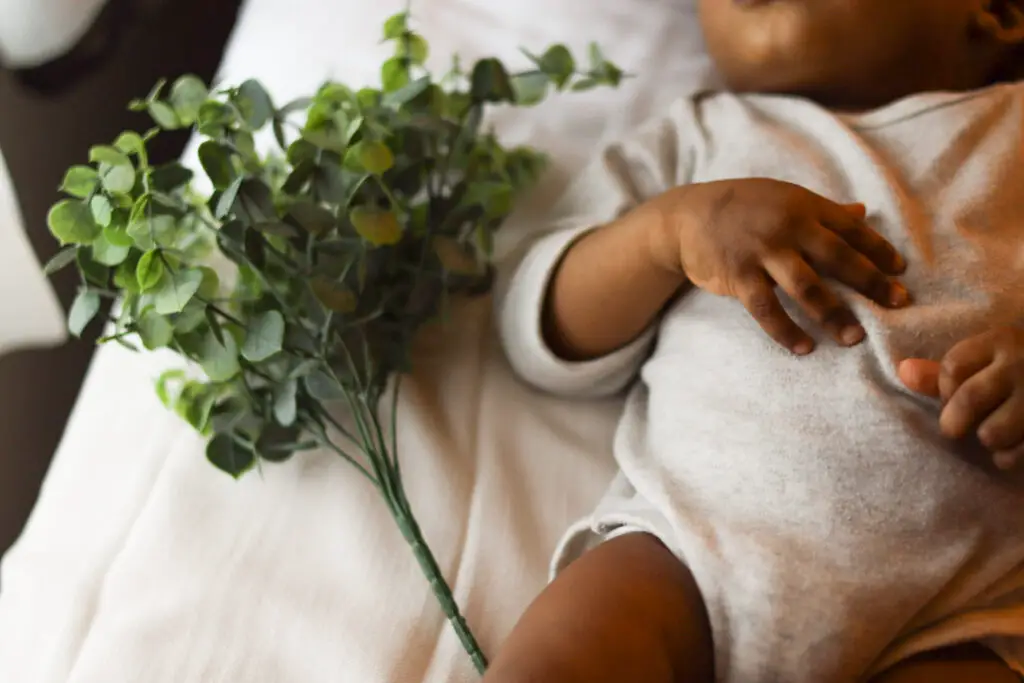 Baby laying down next to a leaf