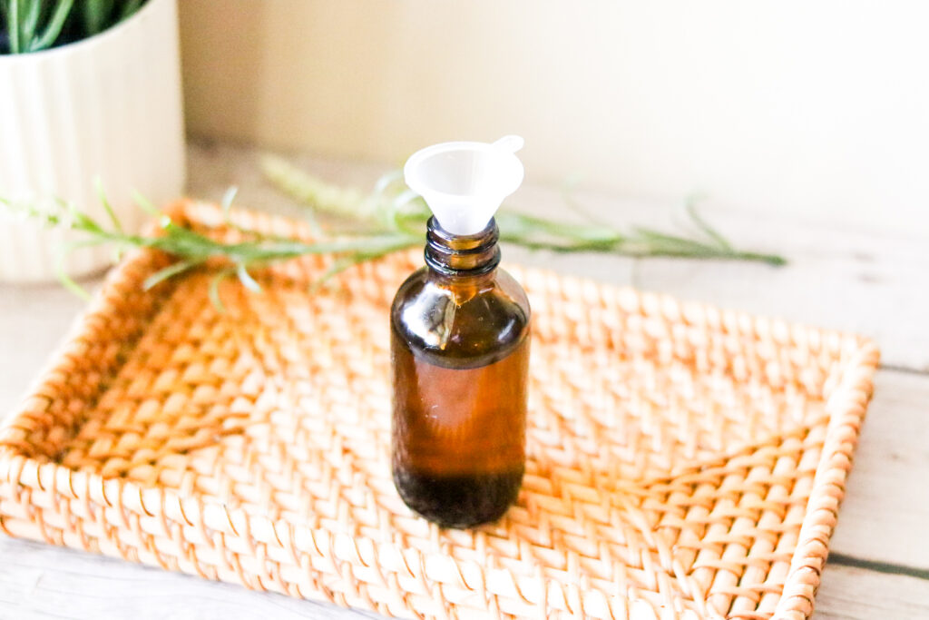 pouring oils in amber bottle for Newborn Hair Oil 