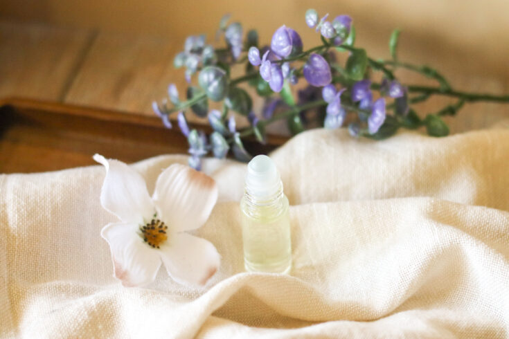sandalwood fragrance perfume on linen cloth with purple plant and jasmine flower