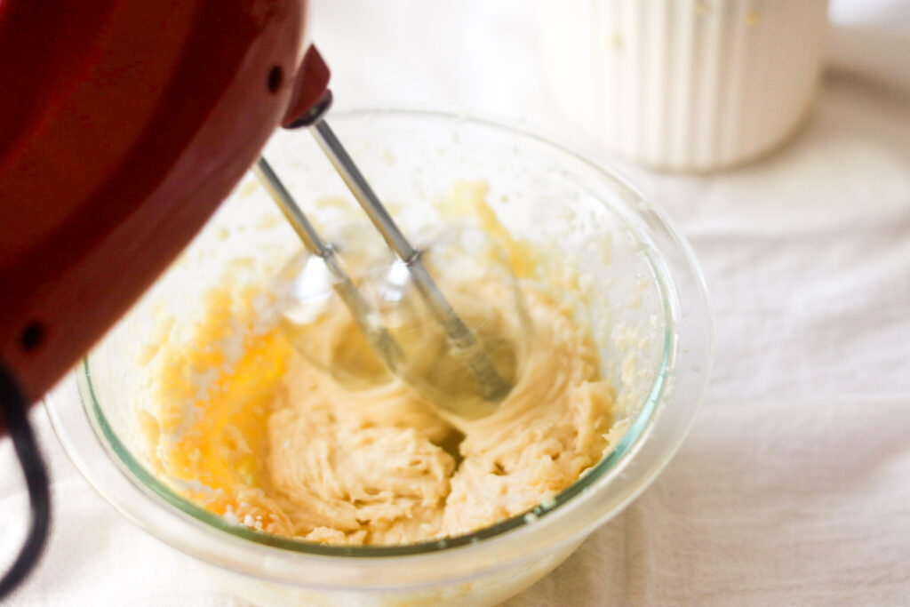 using a hand mixer to mix ingredients for the whipped honey butter