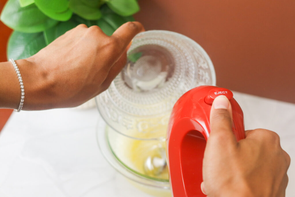 using a hand mixture to mix in magnesium oil and other ingredients for the cream of magnesium