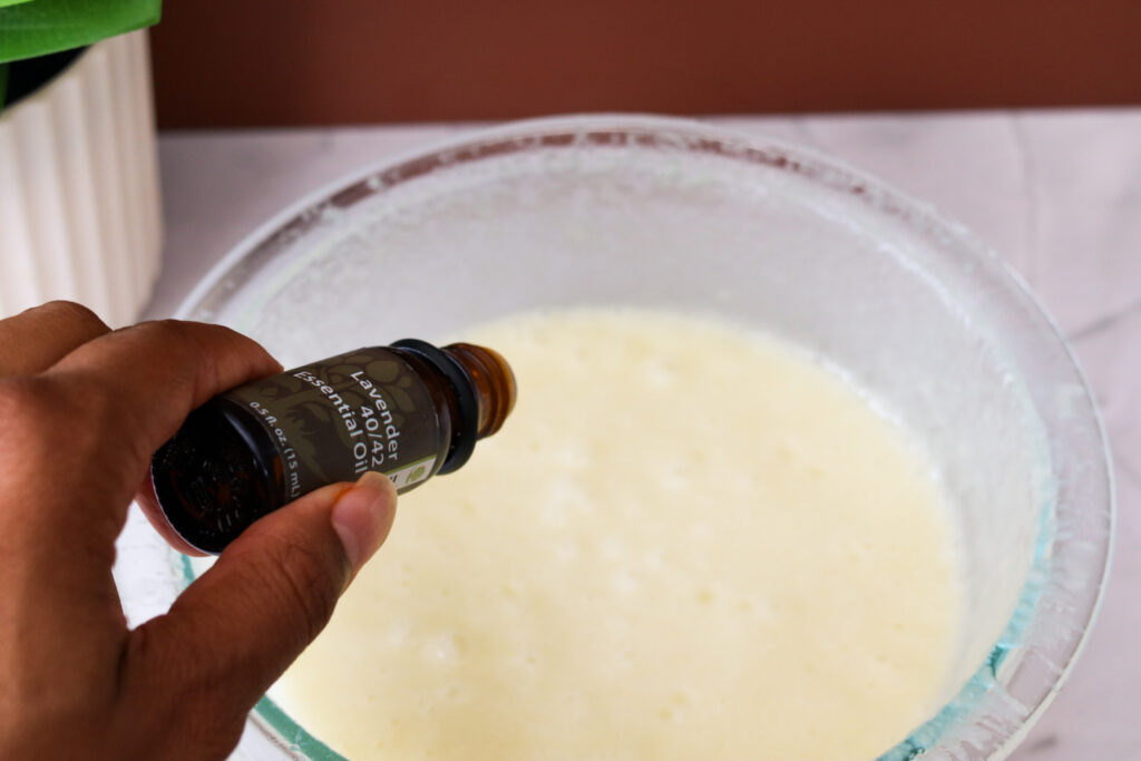 adding lavender essential oil to ingredient bowl