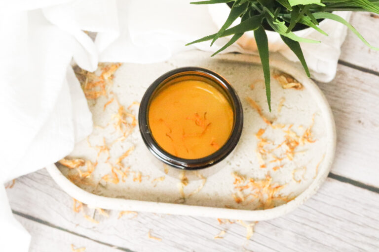 homemade calendula salve in amber jar on stone tray