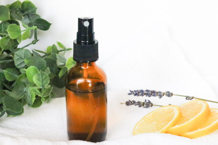 air freshener for the bathroom next to lemons on white towel