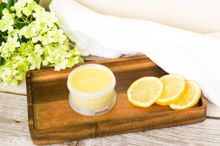 beeswax for wood on wooden tray next to lemon slices