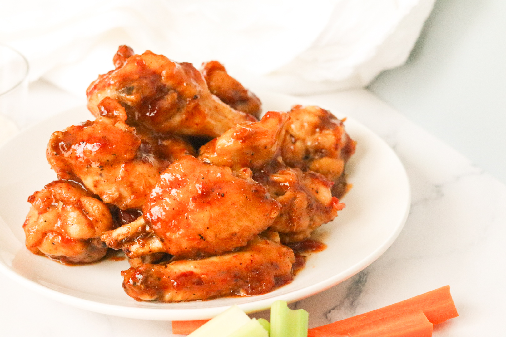 sweet chili wings on plate next to celery and carrots