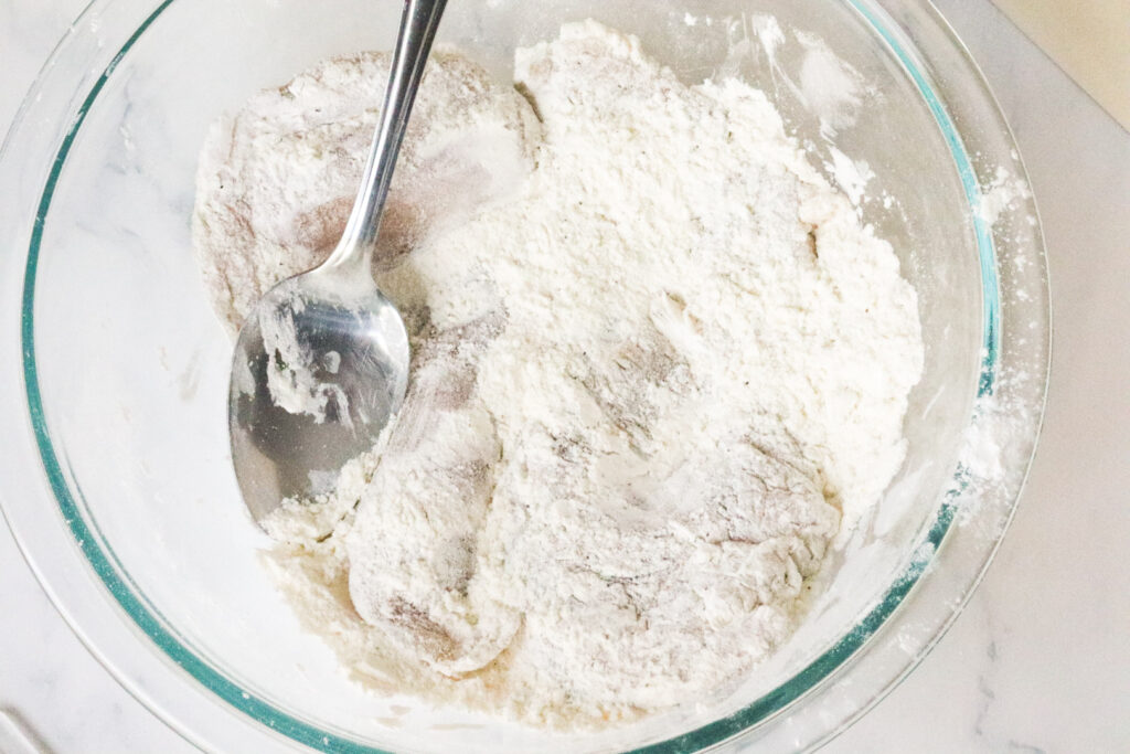 tossing chicken in flour and cornstarch 