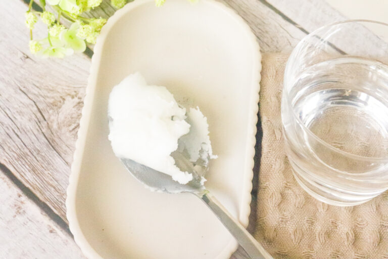 advantages of oil pulling with coconut oil with coconut oil on metal spoon on tray with water